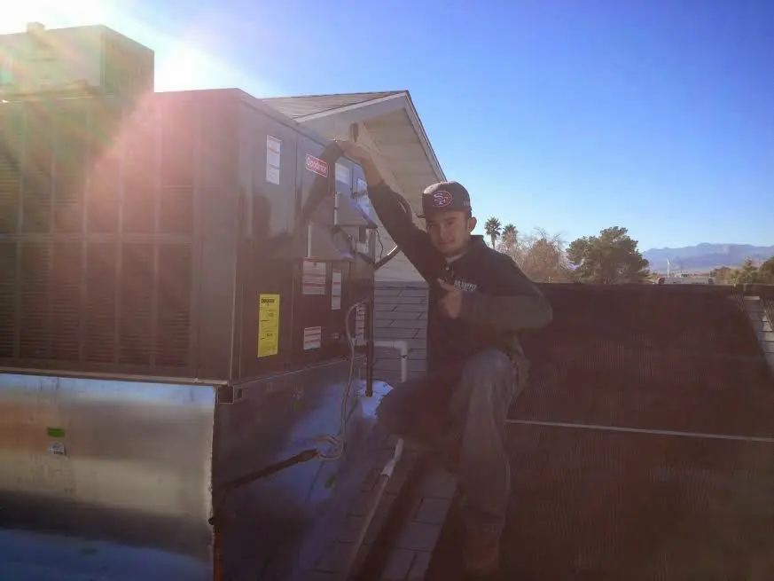 HVAC technician performing AC Tune-Up on a rooftop unit in North Hempstead